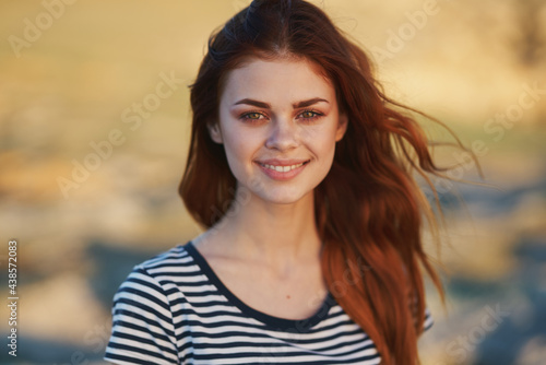 happy woman in striped t-shirt outdoors smiling