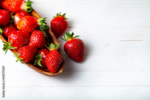 Ripe strawberries in a wooden bowl