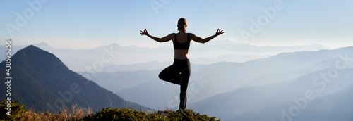 Back view of young woman doing meditation on fresh air. Concept of harmony with nature. Panorama