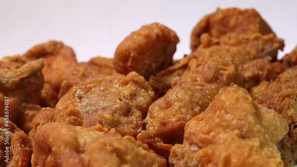 Light battered deep fried chicken variety mix pieces pile flaky meat on white background sprinkled with salt pepper Light battered deep fried chicken variety mix pieces pile flaky meat on white background sprinkled with salt pepper