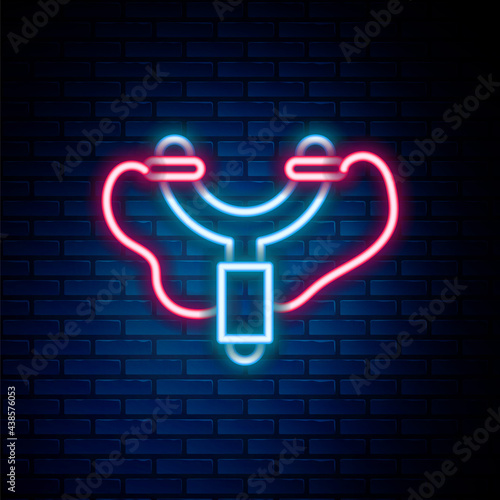Glowing neon line Slingshot icon isolated on brick wall background. Colorful outline concept. Vector