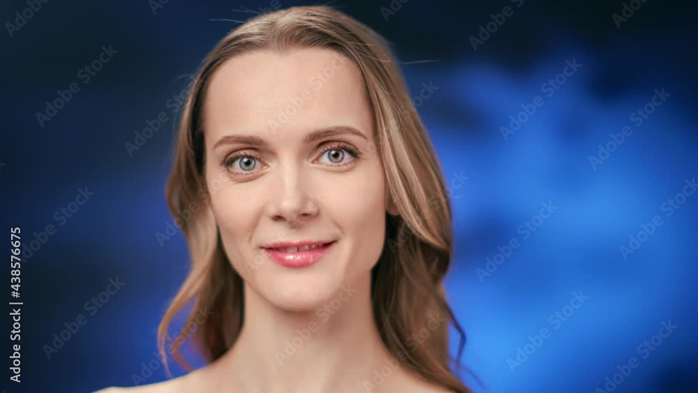 Closeup portrait of beautiful young blonde woman with perfect skin posing isolated at blue gradient Closeup portrait of beautiful young blonde woman with perfect skin posing isolated at blue gradient