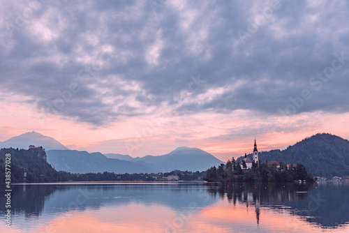Lake Bled in Slovenia viewed from the ground showing the pilgrimage church at sunrise in beautiful orange colors