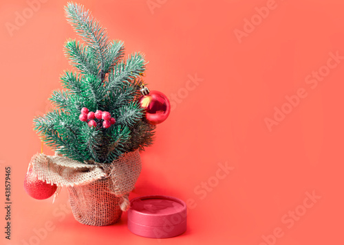 little Christmas tree with toys on a red background with a place for text