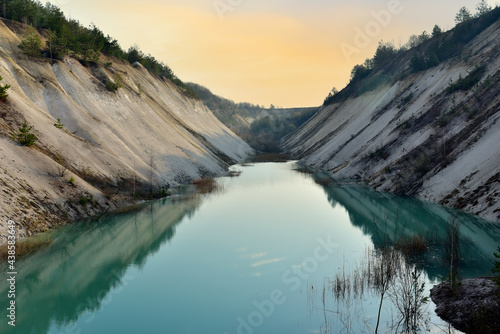 Artificial lake in a chalk quarry in Belarus at Krasnoselsky. Turquoise background of the clear water in summer season in open pit. Technogenic mountains formed during chalk mining. Amazing landscape