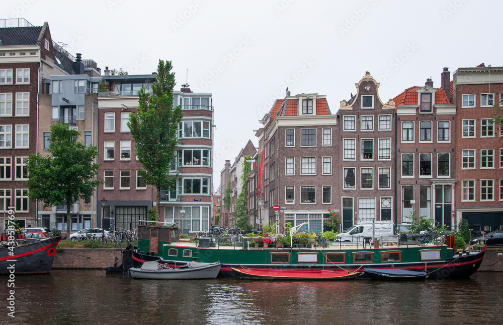 AMSTERDAM, NETHERLANDS. JUNE 06, 2021. Beautiful view of Amsterdam with typical dutch houses, bridges and chanel.