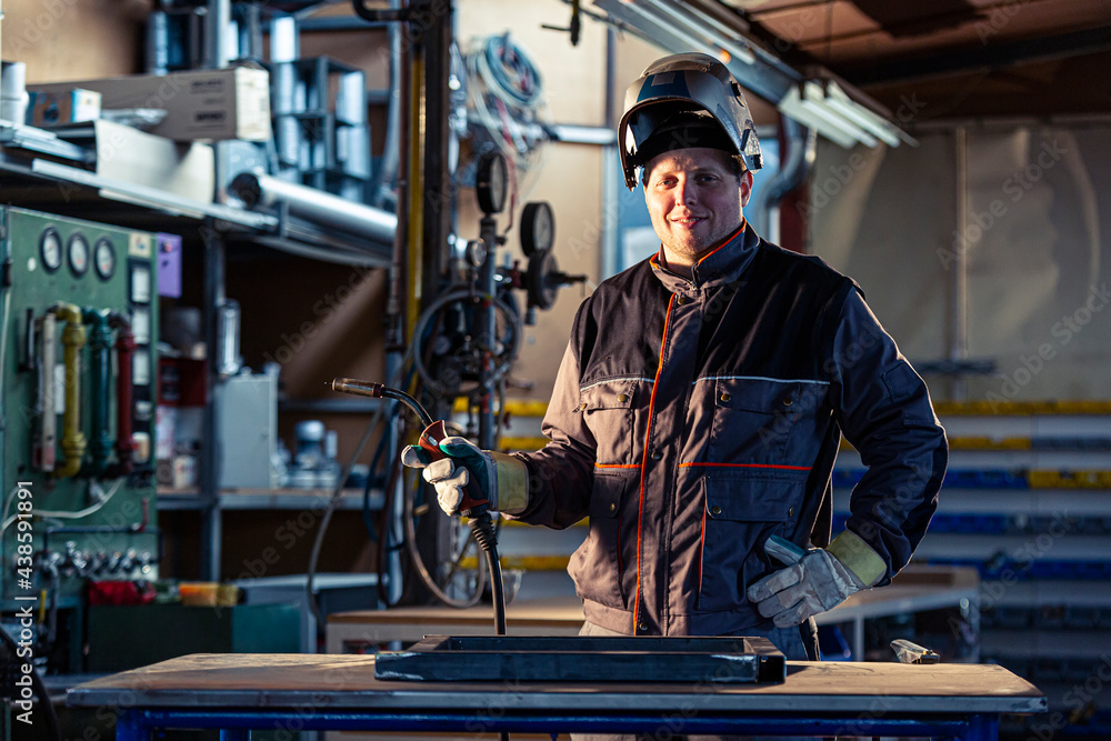 Portrait of a smiling welder posing in the factory Portrait of a smiling welder posing in the factory