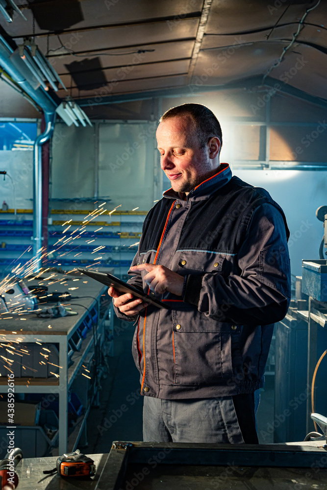 The handyman with a tablet in his workshop