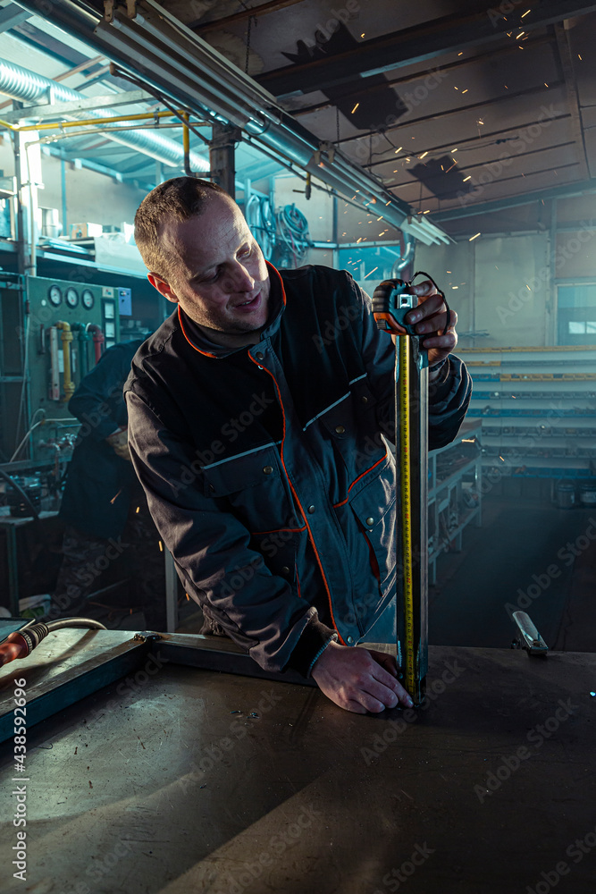 The handyman measuring the bar in the workshop The handyman measuring the bar in the workshop