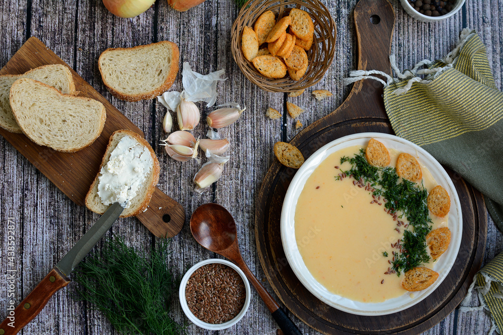 Fototapeta premium Creamy potato soup with cheese, croutons and herbs. Top view