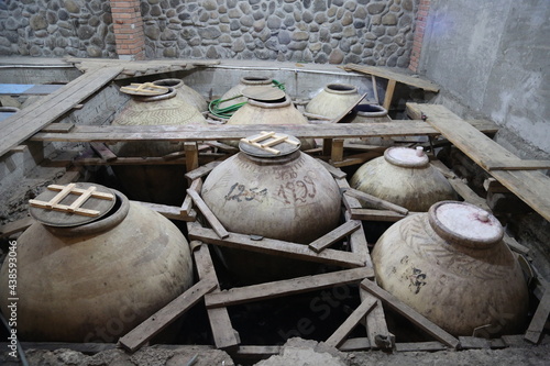 Old ceramics wine jars called kvevri at the wine factory in Georgia. Traditional ceramic pottery barrel for wine.
