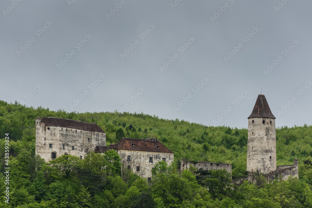 old castle in green hills and rain clouds detail
