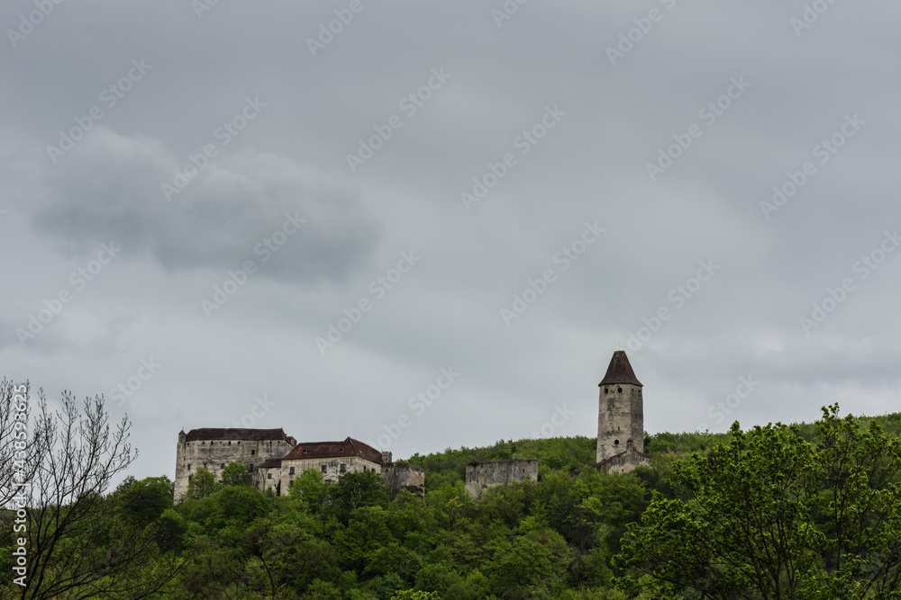 old castle in green hills with many trees and rain clouds old castle in green hills with many trees and rain clouds