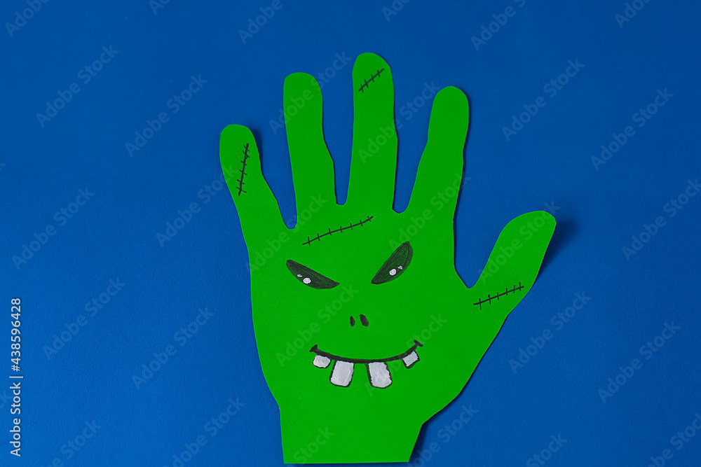 Step 3. Step-by-step instructions on how to make a funny hand-shaped monster out of colored paper. DIY concept. Children's art project. Halloween decoration