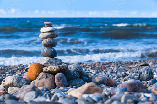 Pebble Stone Tower at Sea Shore   Natural stones stacked in balance  at windy shore and sound of the sea waves  copy space 
