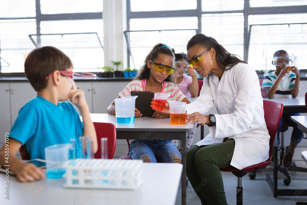 African american female teacher teaching chemistry to a girl during science class at laboratory African american female teacher teaching chemistry to a girl during science class at laboratory