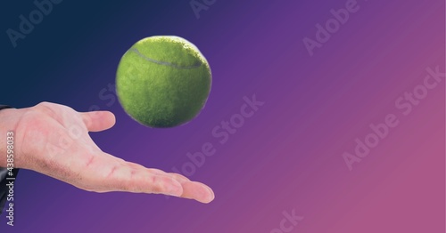 Composition of tennis ball over man's hand on purple background © vectorfusionart