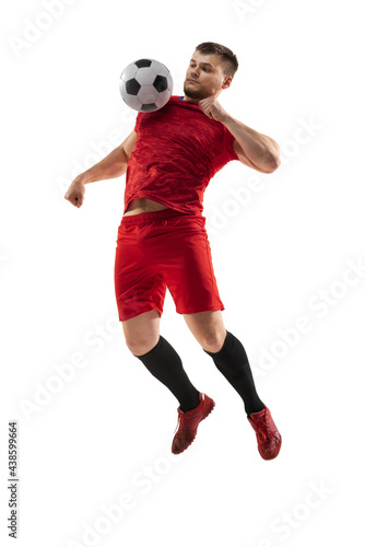 Powerful, flying above the field. Young football, soccer player in action, motion isolated on white background . © master1305