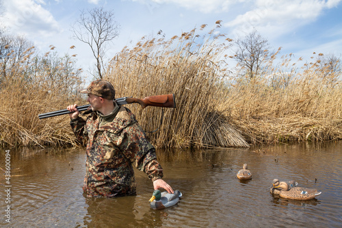 hunter walks on water with tied plastic dummy ducks photo