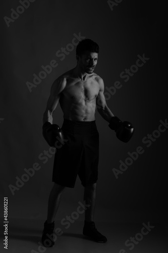 Boxer in darkness with shadows in black and white