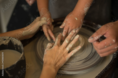 hands make a clay product out of clay on a circle