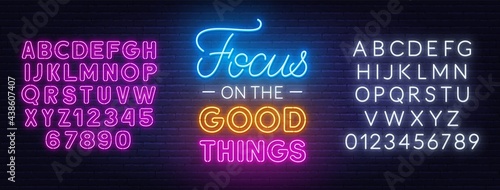 Focus on the Good Things neon lettering on brick wall background.