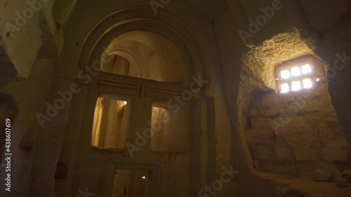 Amazing well conserved ruins of ancient church in Cappadocia, Turkey. Scenic interior of cathedral with high ceiling, many columns and archs. Cave church carved in vulcanic rock. Black dog standing photo