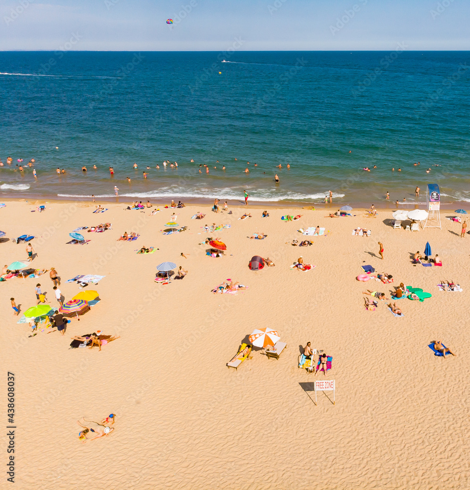 Aerial drone top view on the sand beach. Umbrellas, sand and sea waves. View from above