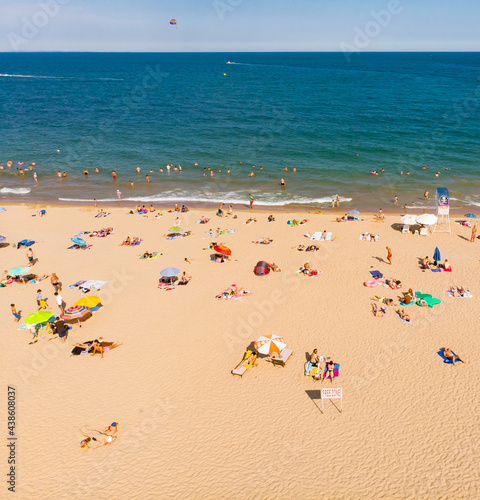 Aerial drone top view on the sand beach. Umbrellas, sand and sea waves. View from above © Marharyta