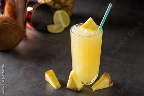 Cocktail with pineapple, coconut and lemon on stone background photo