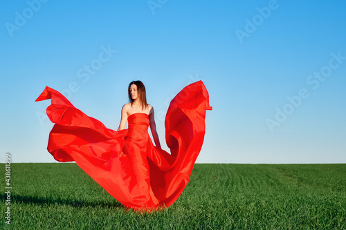 Obraz na płótnie girl in a red dress in the field w salonie