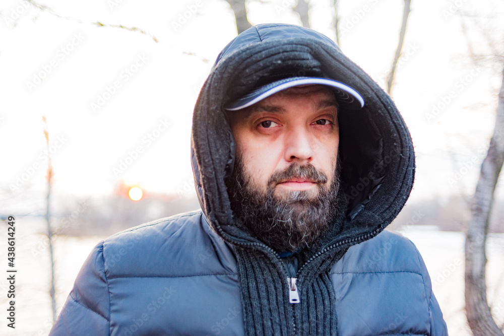 Headshot of a man in a hood. Man in a gray jacket with a hood. Headshot of a man in a hood. Man in a gray jacket with a hood.