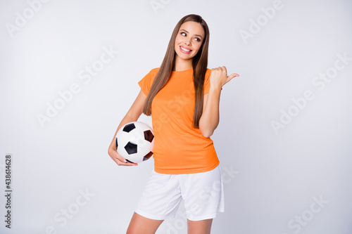 Photo of captain soccer team joyful lady direct thumb finger empty space euro cup 2020 league bets hold ball wear national team football uniform t-shirt shorts isolated white color background