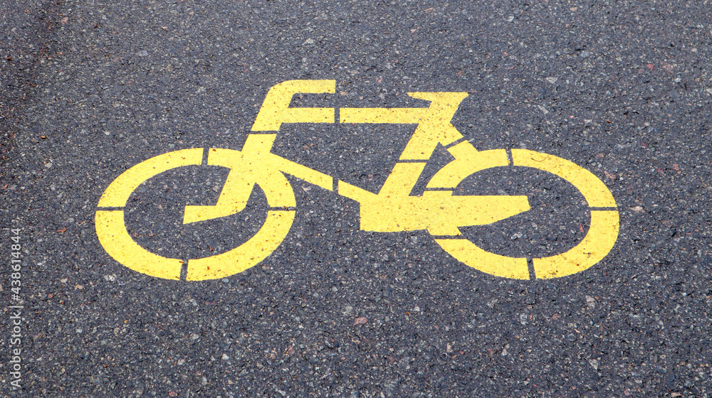 Bicycle symbol representing a path for bicycles. Yellow painted sign for bicycles on the asphalt. Flat lay, top view. Bicycle symbol representing a path for bicycles. Yellow painted sign for bicycles on the asphalt. Flat lay, top view.