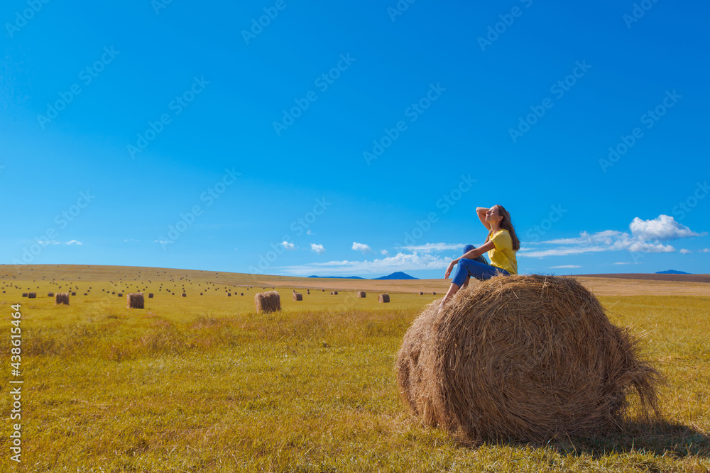 a girl is sunbathing in the hay. village life: harvesting hay for the winter. animal feed. a girl is sunbathing in the hay. village life: harvesting hay for the winter. animal feed.