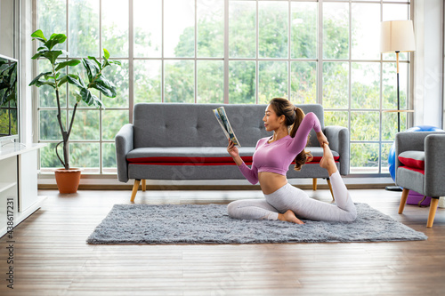 Asian woman post yoga one leg pigeon for practicing and reading magazine