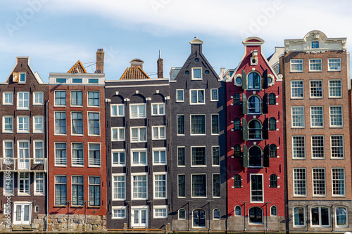 Architecture features traditional houses, Typical dutch house at Damrak canal, An avenue running between Amsterdam Centraal in the north and Dam Square in the south, Netherlands.