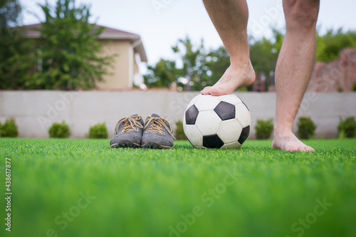 Legs of unrecognizable barefoot football player against artificial grass. Soccer ball, street football shoes. Copy space. © sergiophoto