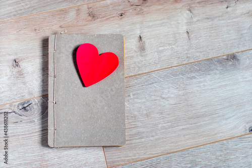 Craft notebook made of gray paper with a red cut out heart as a gift for Valentine s Day. Space for text