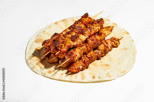 A classic Greek dish is souvlaki, small chicken kebabs. Fast food cooked on skewers and grills. Shish kebab on pita bread on a white background.