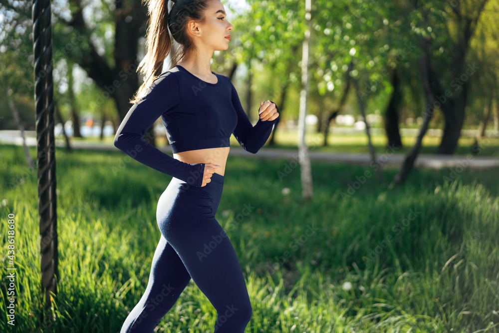 Athletic fit young woman jogging early in the morning in park Athletic fit young woman jogging early in the morning in park