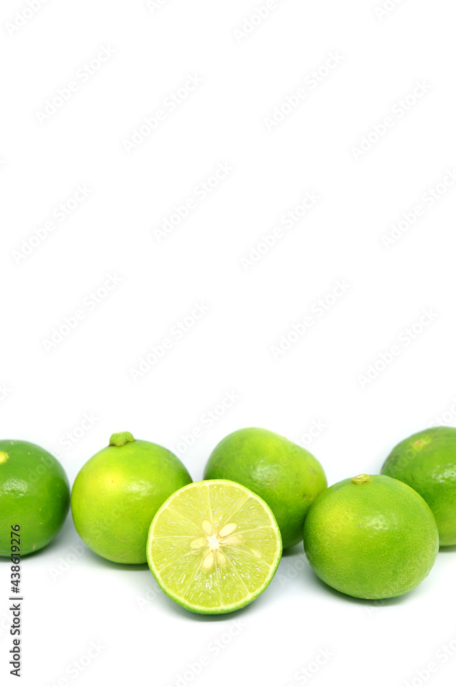 Cross section fresh key lime with heap of whole fruits in row on white background Cross section fresh key lime with heap of whole fruits in row on white background