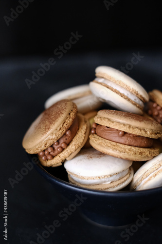 Macaroons on dark background, colorful french cookies macaroons. Macaroons. Vanilla and chocolate dessert. Healthy no sugar vegetarian. Gift for 8 March - International Women's Day