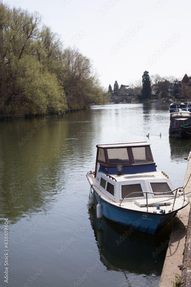 A small boat moored along the Thames River in Maidenhead in the UK