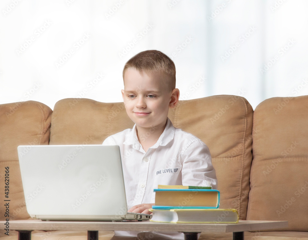 Boy sitting at a table in front of a computer, online learning
Boy sitting at a table in front of a computer, online learning