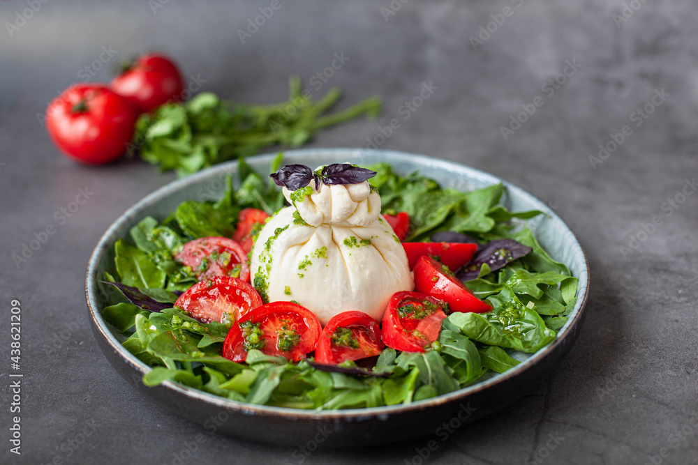 Salad with traditional italian burrata cheese with tomatos, basil and arugula Salad with traditional italian burrata cheese with tomatos, basil and arugula