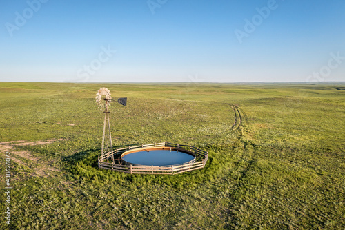 windmill with a water pump and tank  in shortgrass prairie, Pawnee National Grassland in Colorado, aerial view photo