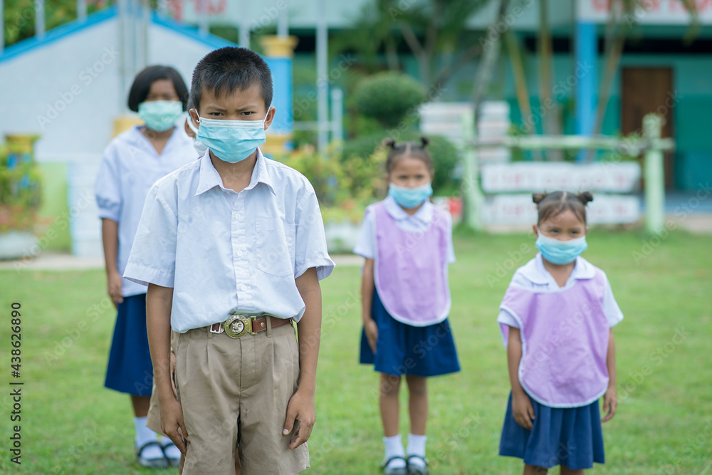 Surin, THAILAND - October 10, 2020:Thai students are sitting in a row to keep social distancing They are aware of Covid-19 and keep social distancing and wearing protective facemasks at school during 