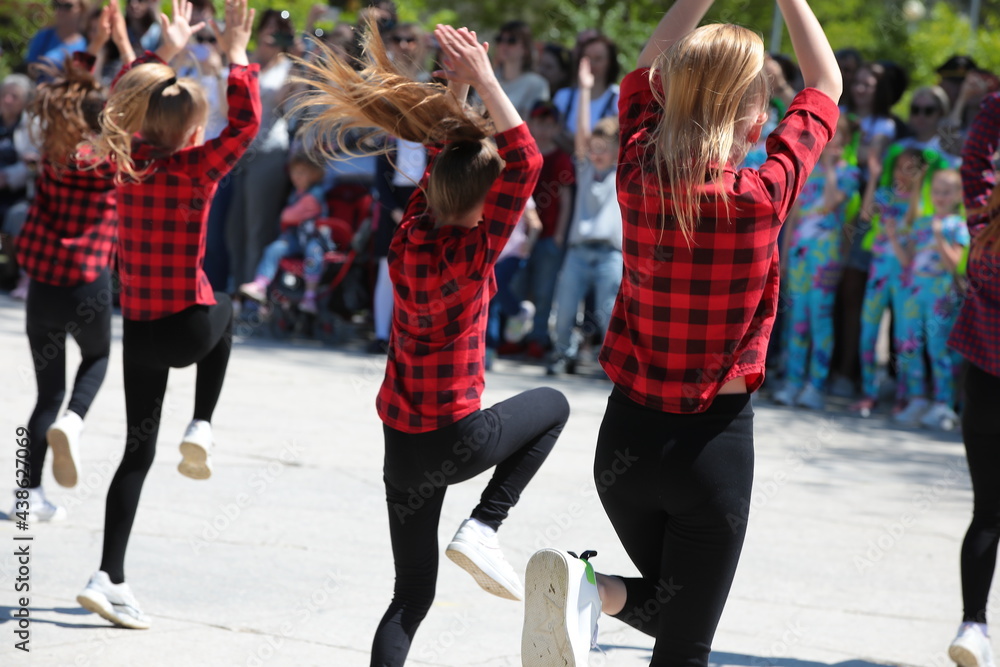 Image of a group of young teenage girls in leggings and a red tartan  dancing at