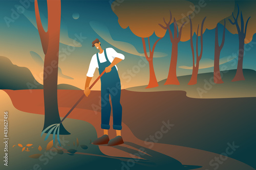 The gardener in the city park in the early morning removes the leaves, ennobling the trees. A man in overalls with a fan rake takes care of the trees. Green city concept.